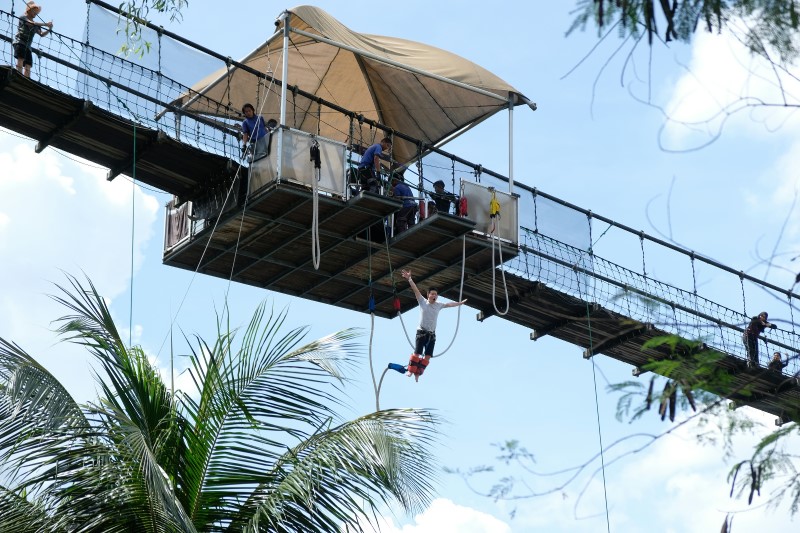 : seorang pria berbaju bungee putih melompat dari jembatan