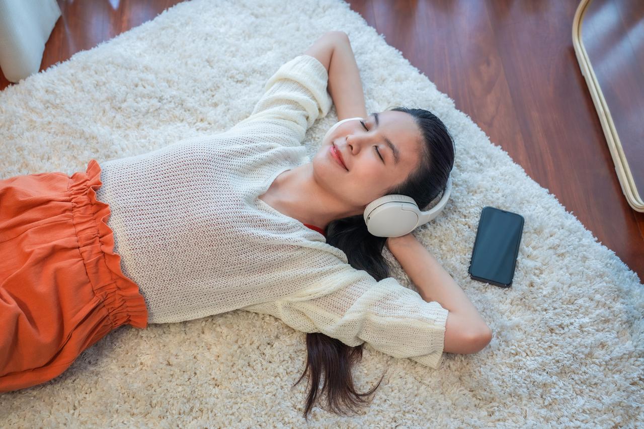 Woman_laying_down_on_rug_with_mobile_listening_to_music_(1).jpg