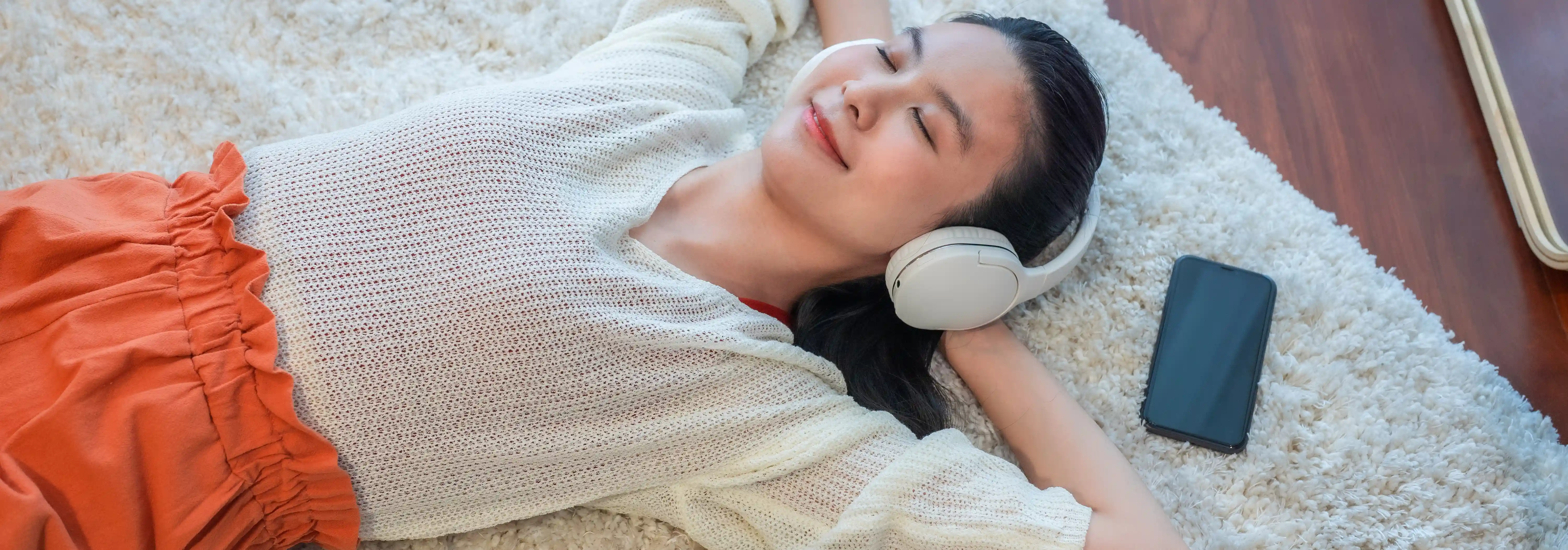 wanita yang sedang mendengarkan musik