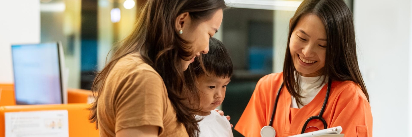 Seorang ibu muda beserta anak laki-lakinya sedang hasil pemeriksaan di sebuah klinik.
