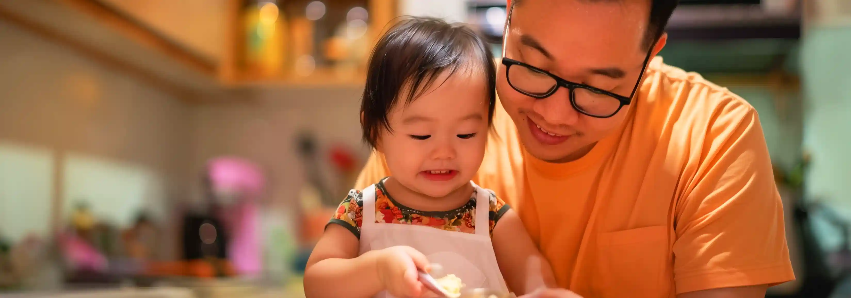 seorang ayah dan anaknya sedang membuat makanan 