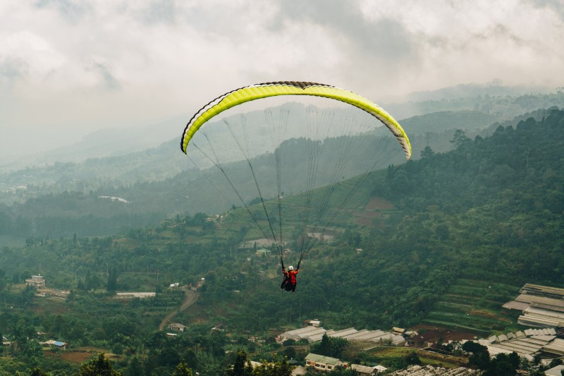 seseorang melakukan paralayang di udara