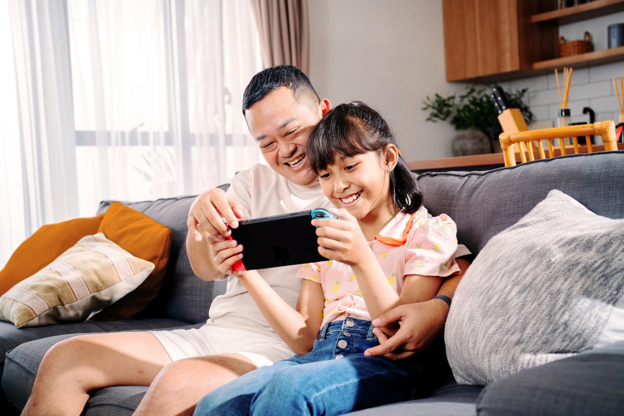 Father_and_daughter_doing_video_call_on_sofa_at_home.jpg