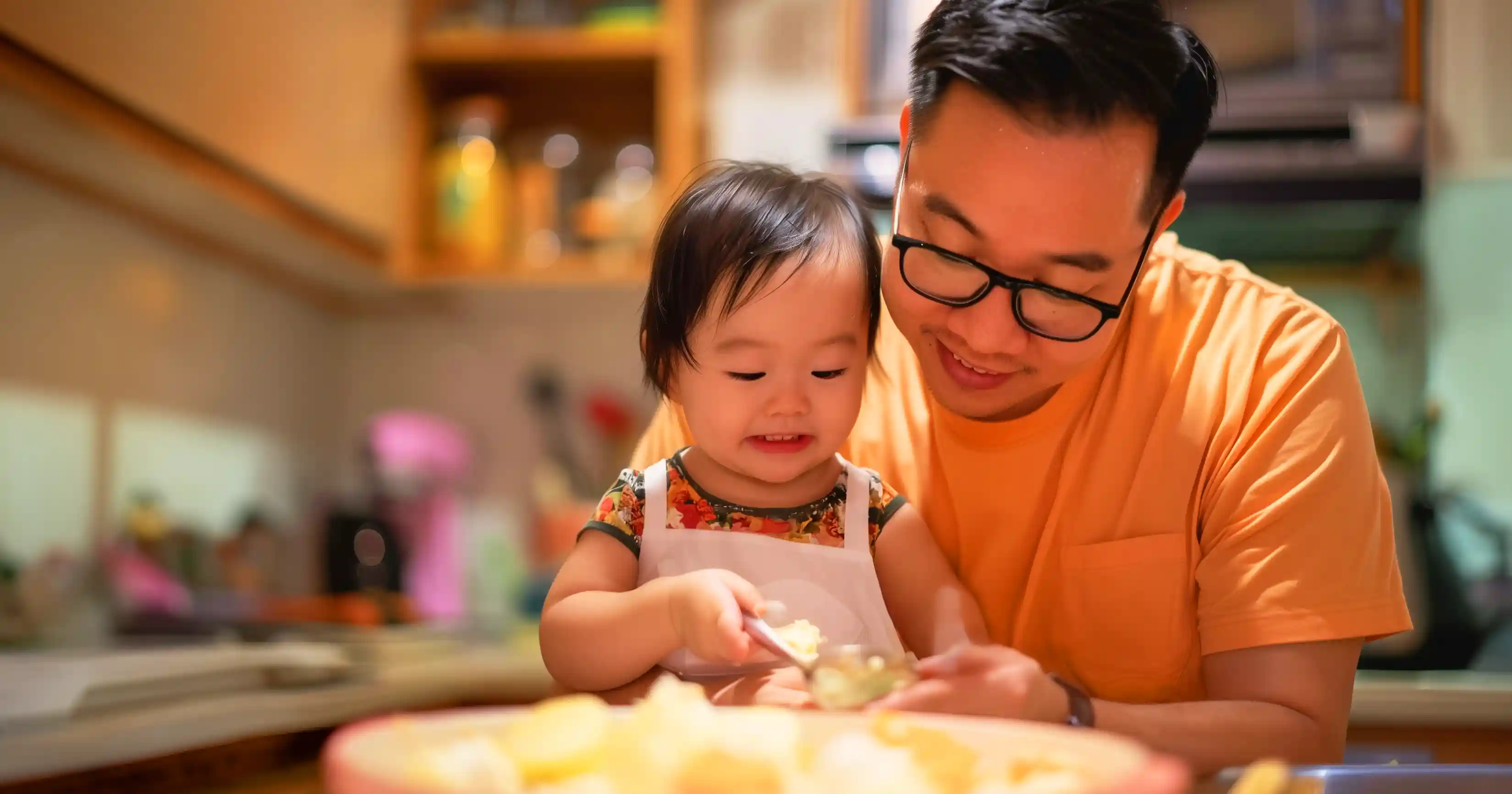 seorang ayah dan anaknya sedang membuat makanan 