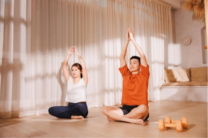 Dua orang sedang melakukan yoga di sebuah ruangan