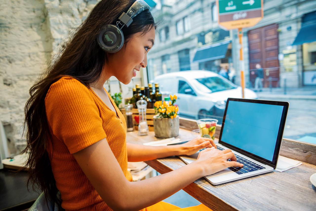 Lady_working_on_a_laptop_at_a_cafe.jpg